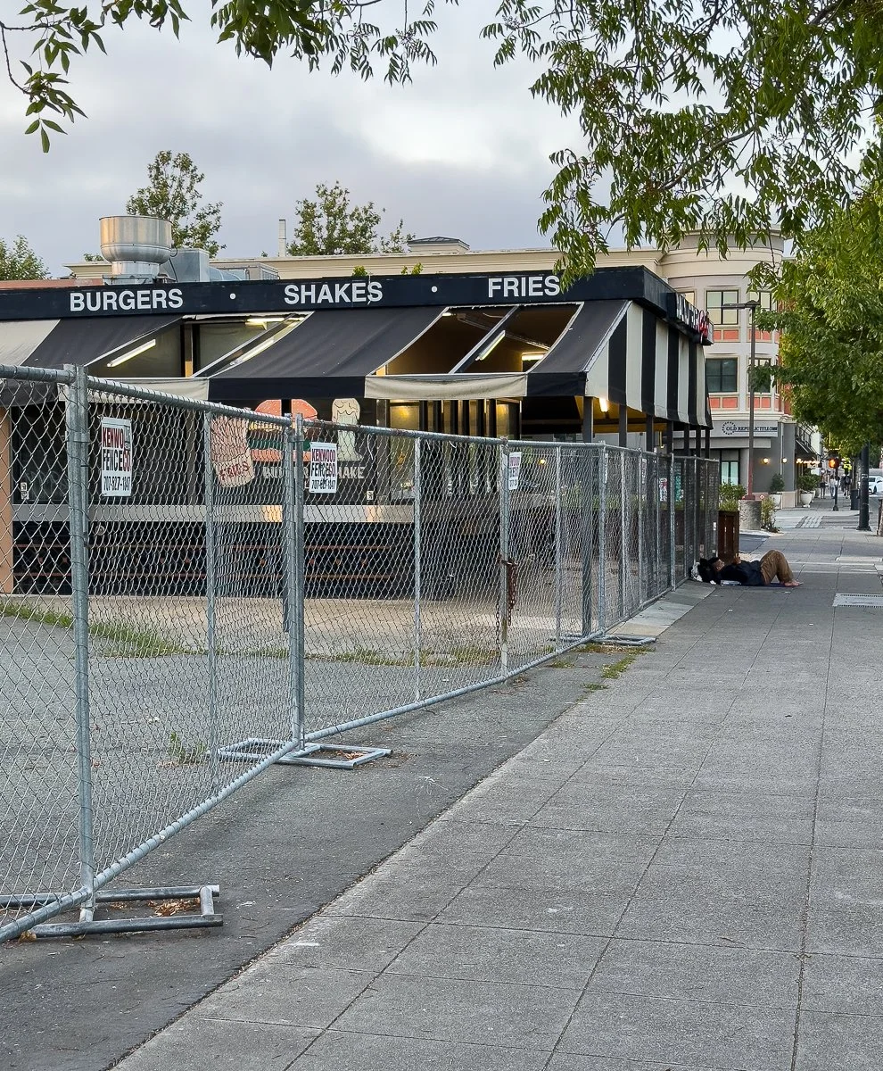 A fenced-off grill with a collapsing awning across from Walnut Park